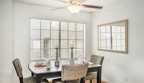 a dining room with a table and chairs and a ceiling fan