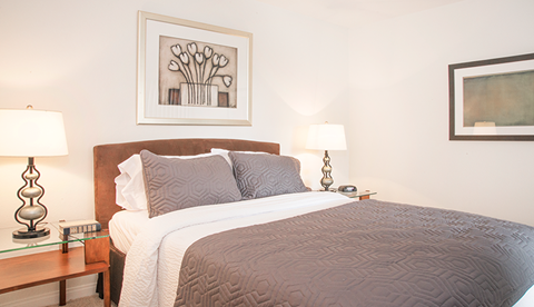 a bedroom with a bed and a painting on the wall
