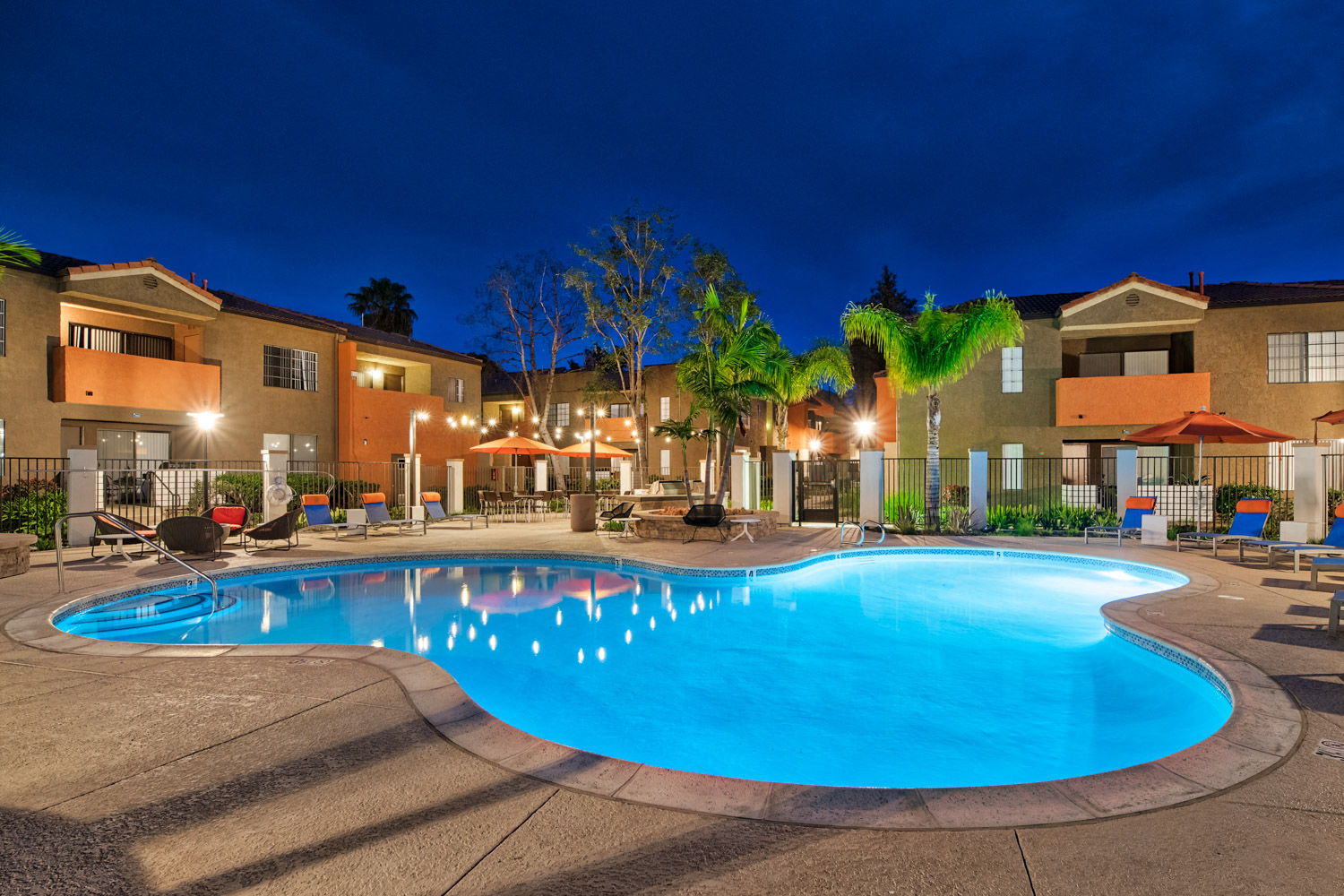 a swimming pool at night at an apartment complex