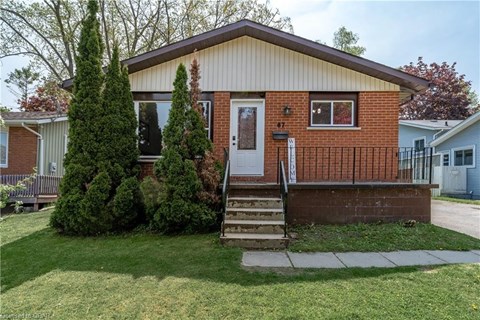 the front of a brick house with a porch and stairs