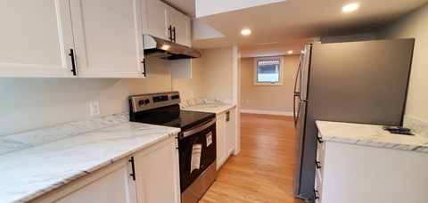 A kitchen with white cabinets and a black stove top oven.