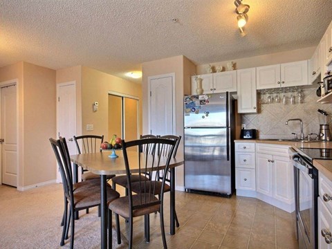 a kitchen with a table and a refrigerator