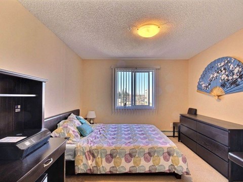 a bedroom with a bed and a television