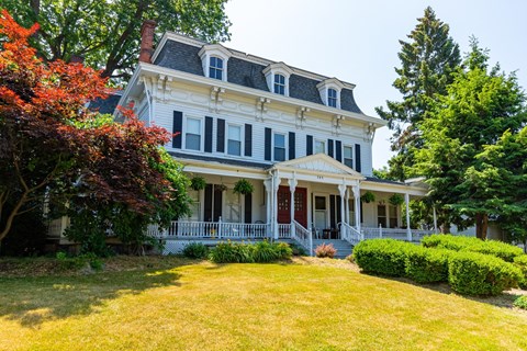 a large white house with a yard in front of it