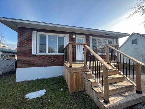 A house with a wooden deck and a red brick wall.