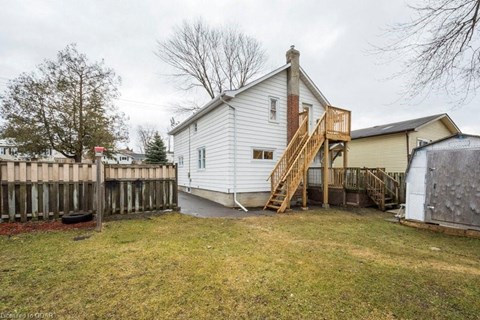 a white house with a yard and a wooden fence