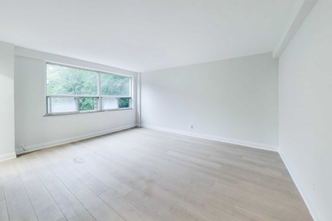 A room with a large window and wooden flooring.