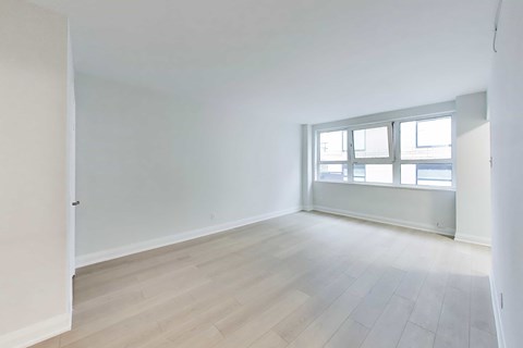 A room with a window and wooden flooring.