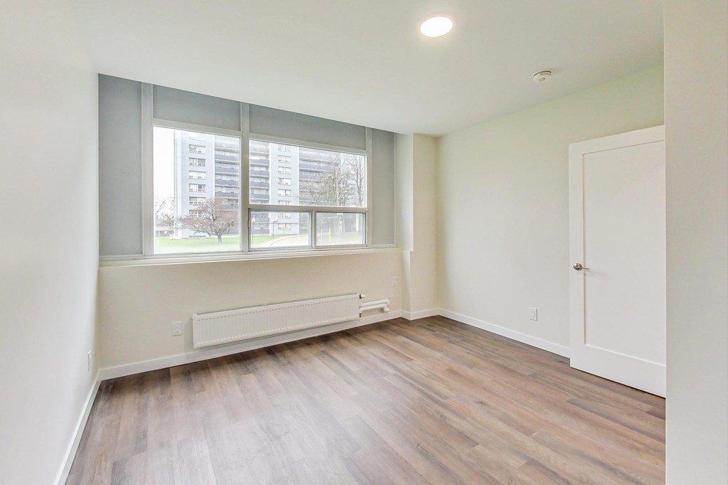 A room with a window and a radiator on the floor.