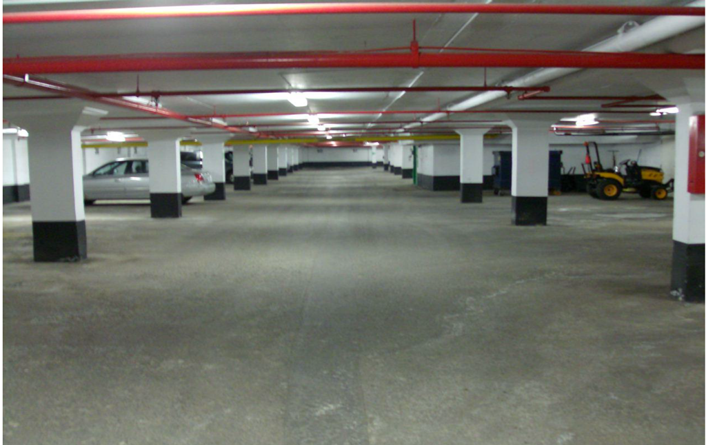 A parking garage with a tractor in the background.