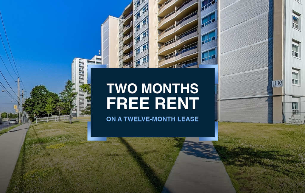 A sign offering two months free rent on a twelve-month lease is displayed in front of apartment buildings.