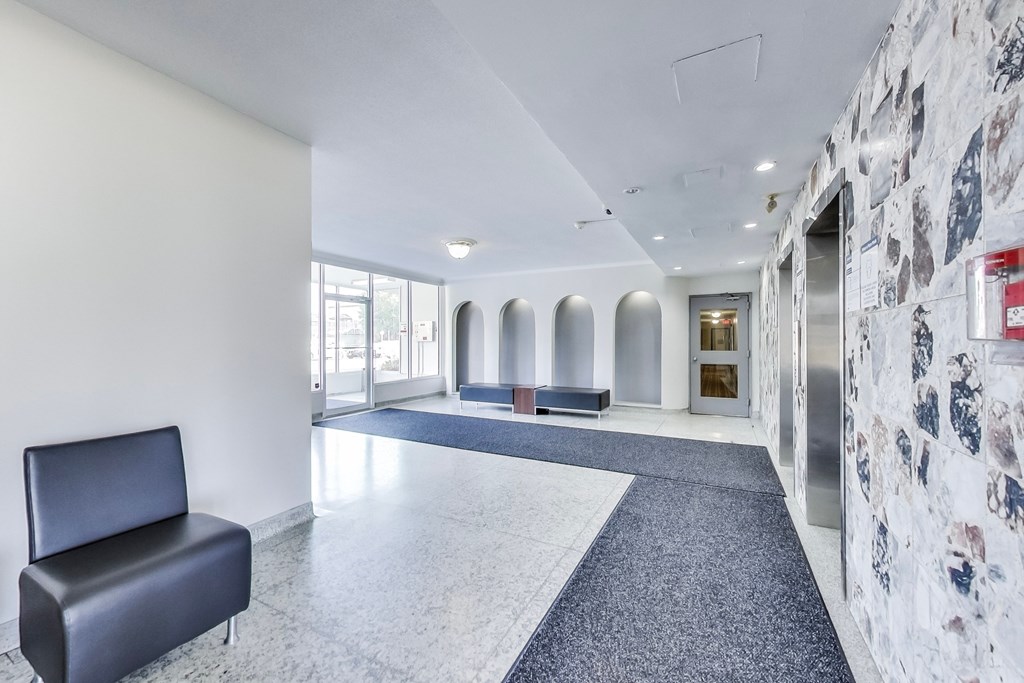 A hallway with a bench and a stone wall.