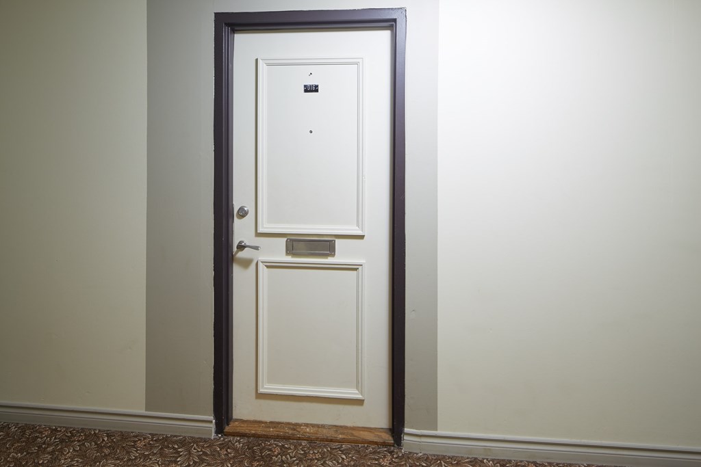 A white door with a black frame is open.