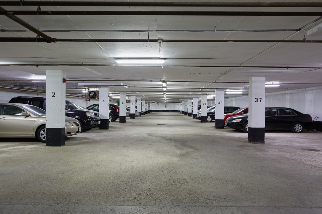 A parking garage with cars parked in rows and numbered posts.