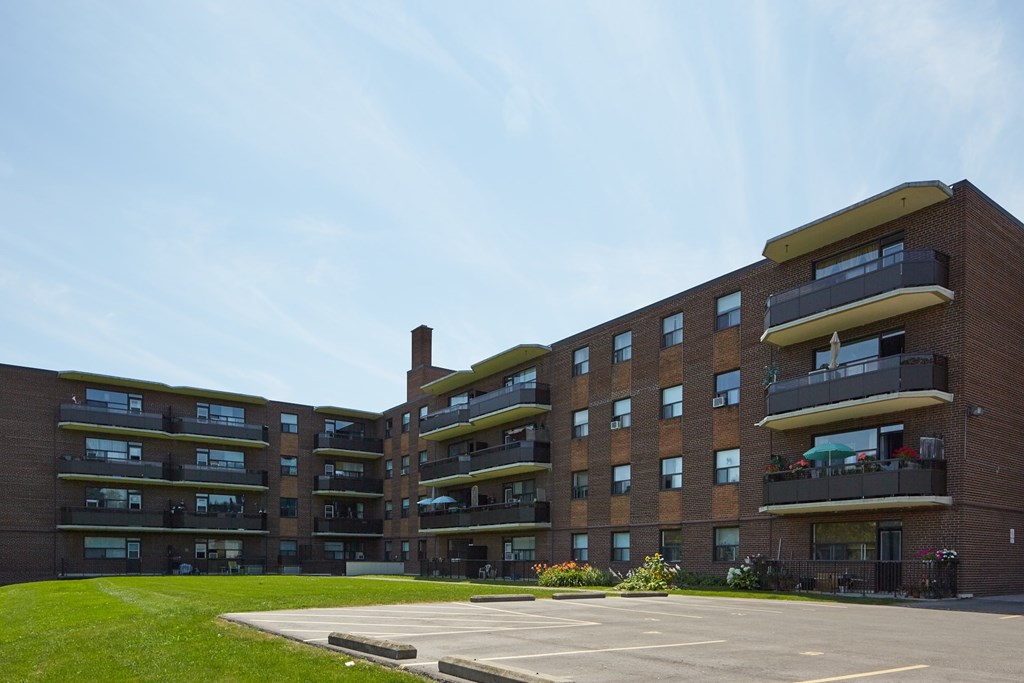 A large brick building with a parking lot in front.