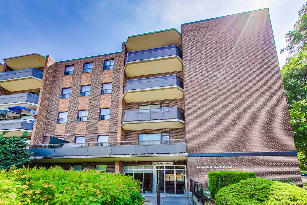 The image shows a multi-story building with a flat facade and balconies.