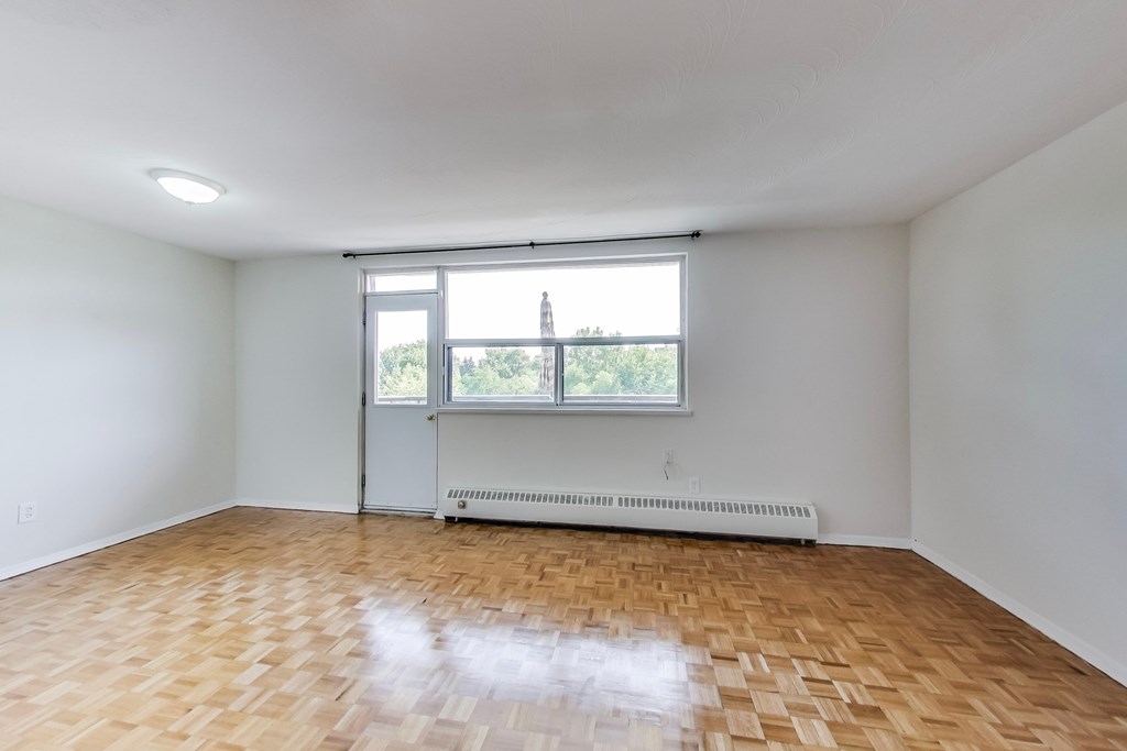 A room with a window and a radiator on the floor.