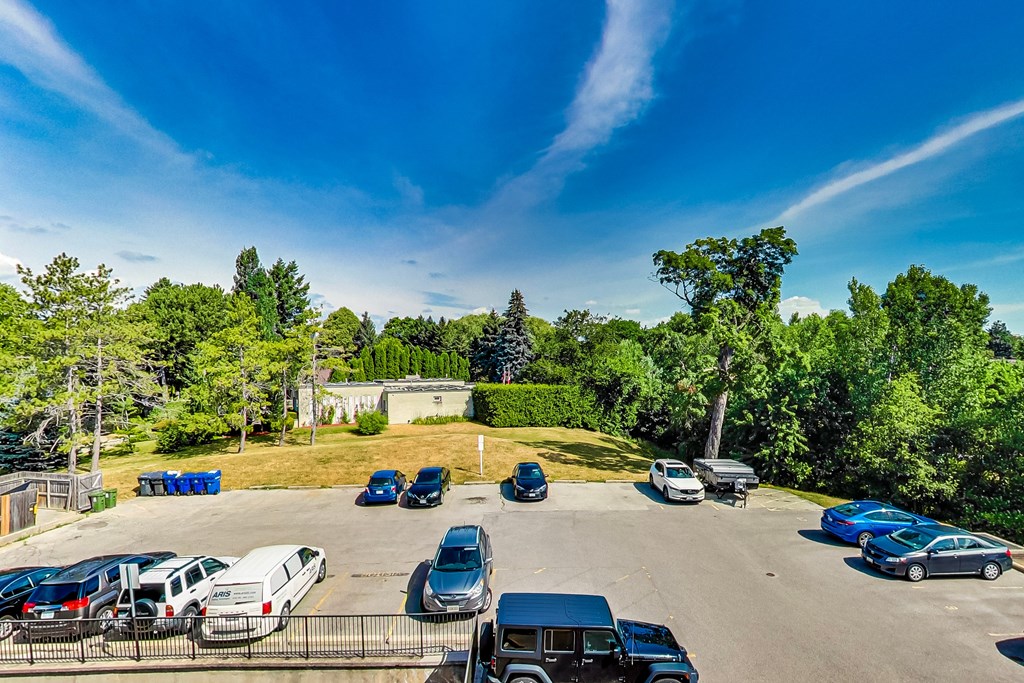 A parking lot with several cars and a building in the background.