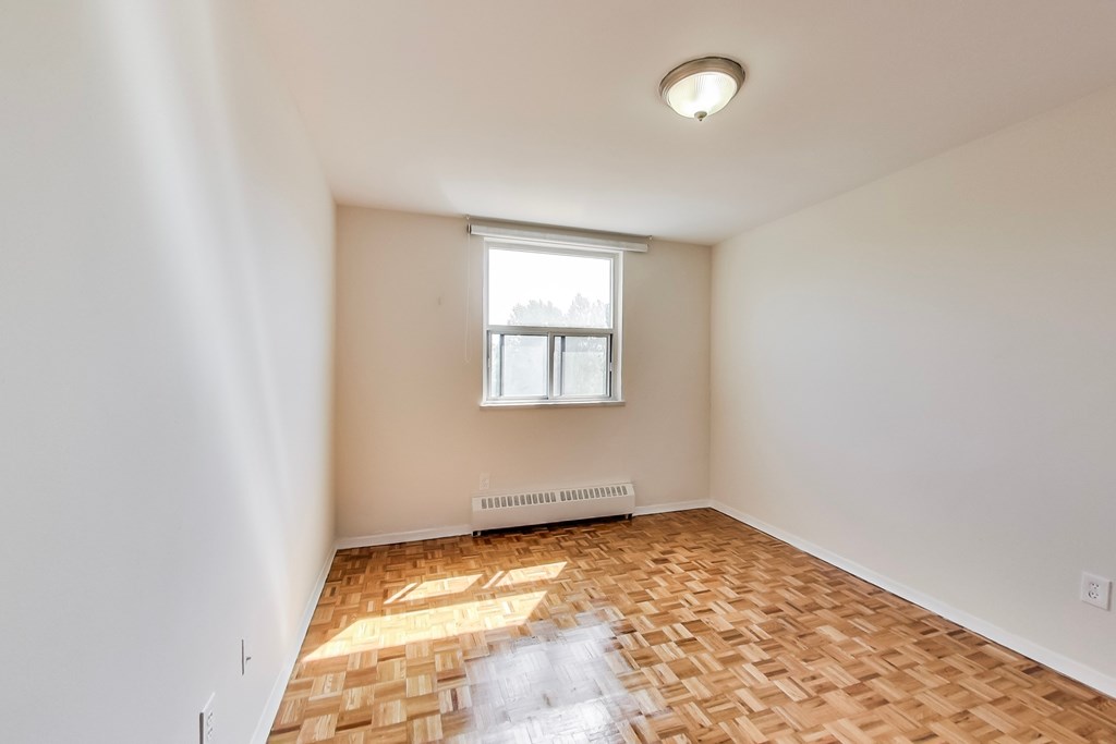 A room with a window and a radiator on the floor.