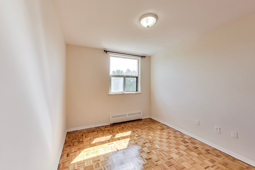 A room with a window and a radiator on the wall.
