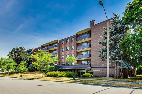 A large apartment building with a parking lot in front.
