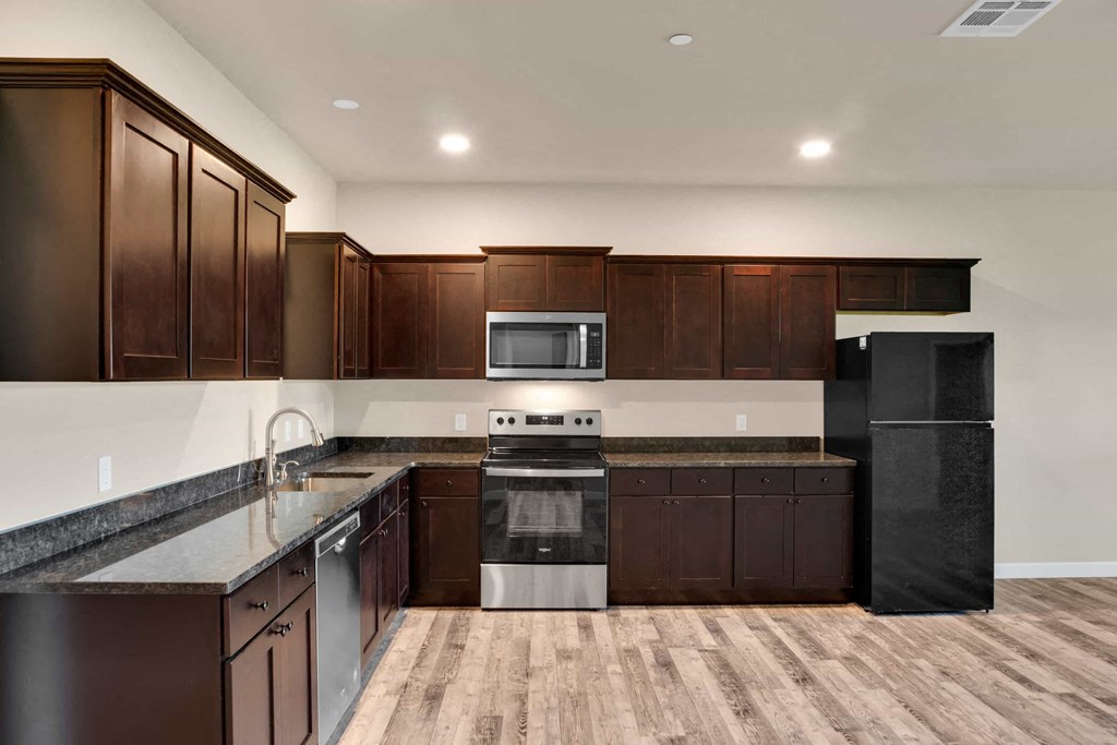 a kitchen with dark wood cabinets and stainless steel appliances