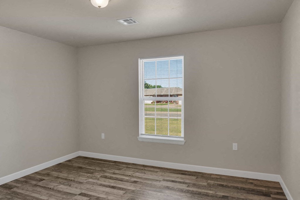 a living room with a window and a wooden floor