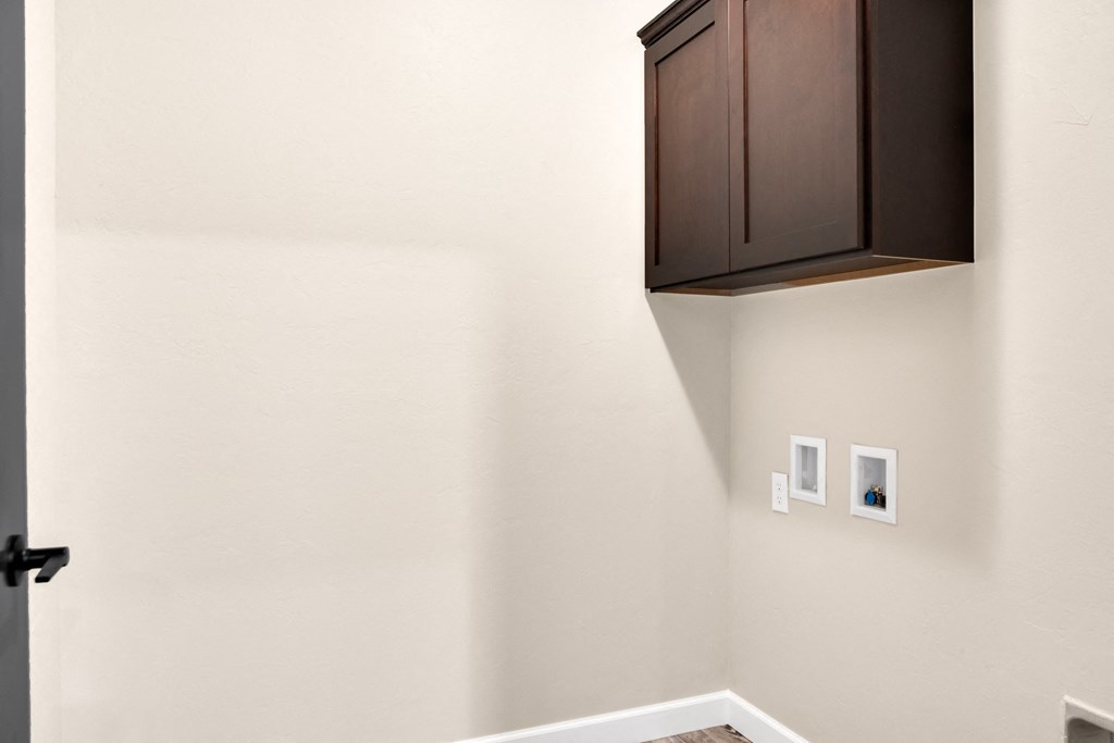 a room with a cupboard and a white wall and a door