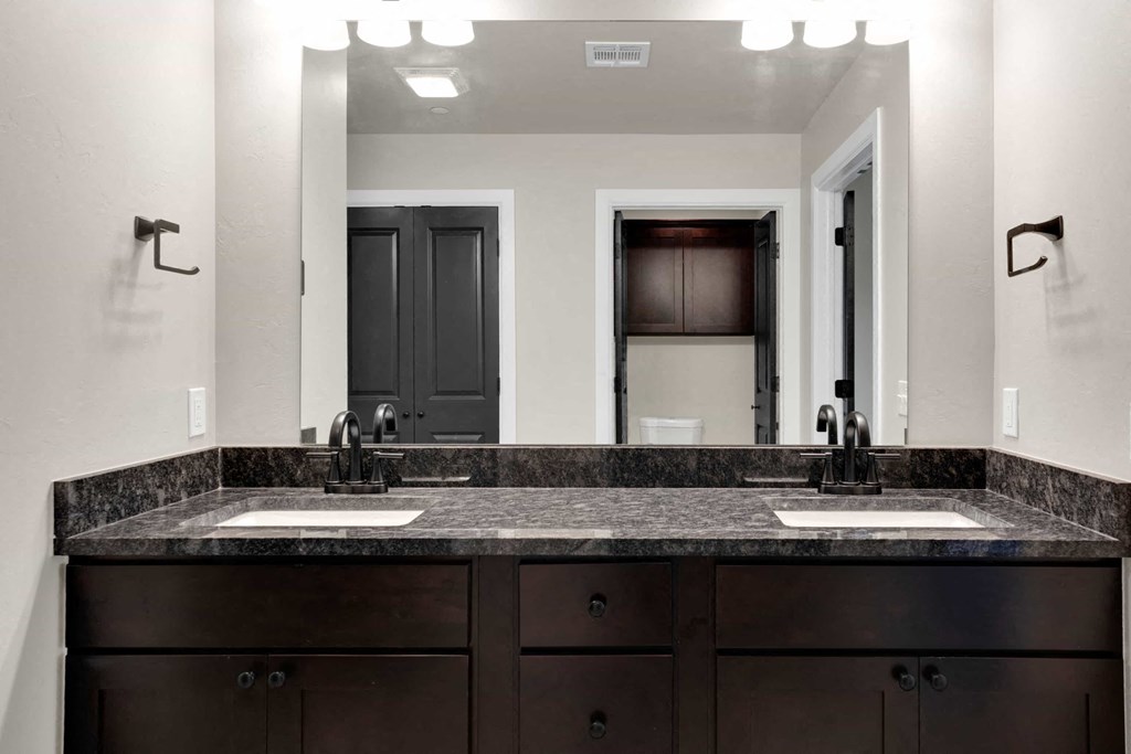 a bathroom with two sinks and a large mirror