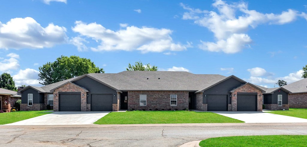 a large brick house with a driveway and grass