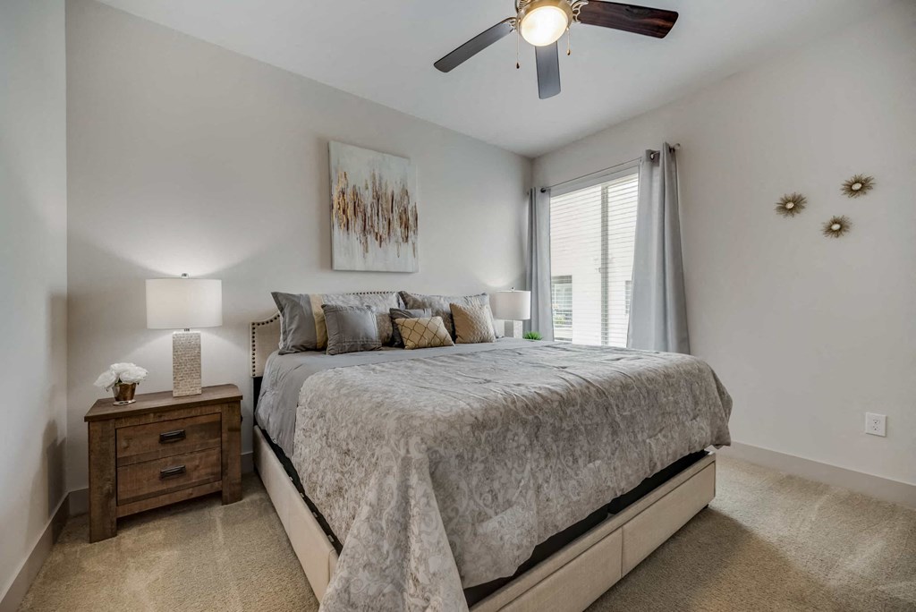 a bedroom with a bed and a ceiling fan