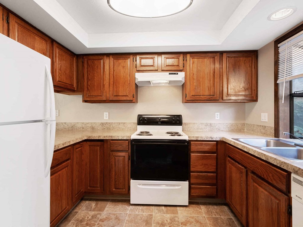 a kitchen with wooden cabinets and a stove and a refrigerator