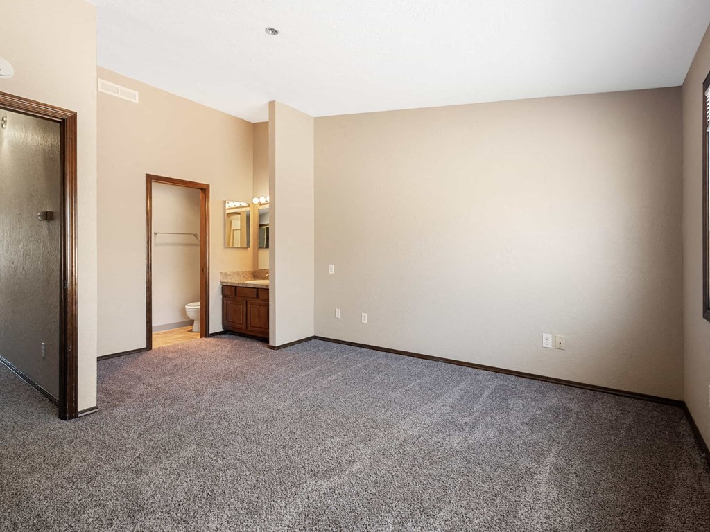 a room with carpet and a door to a bathroom