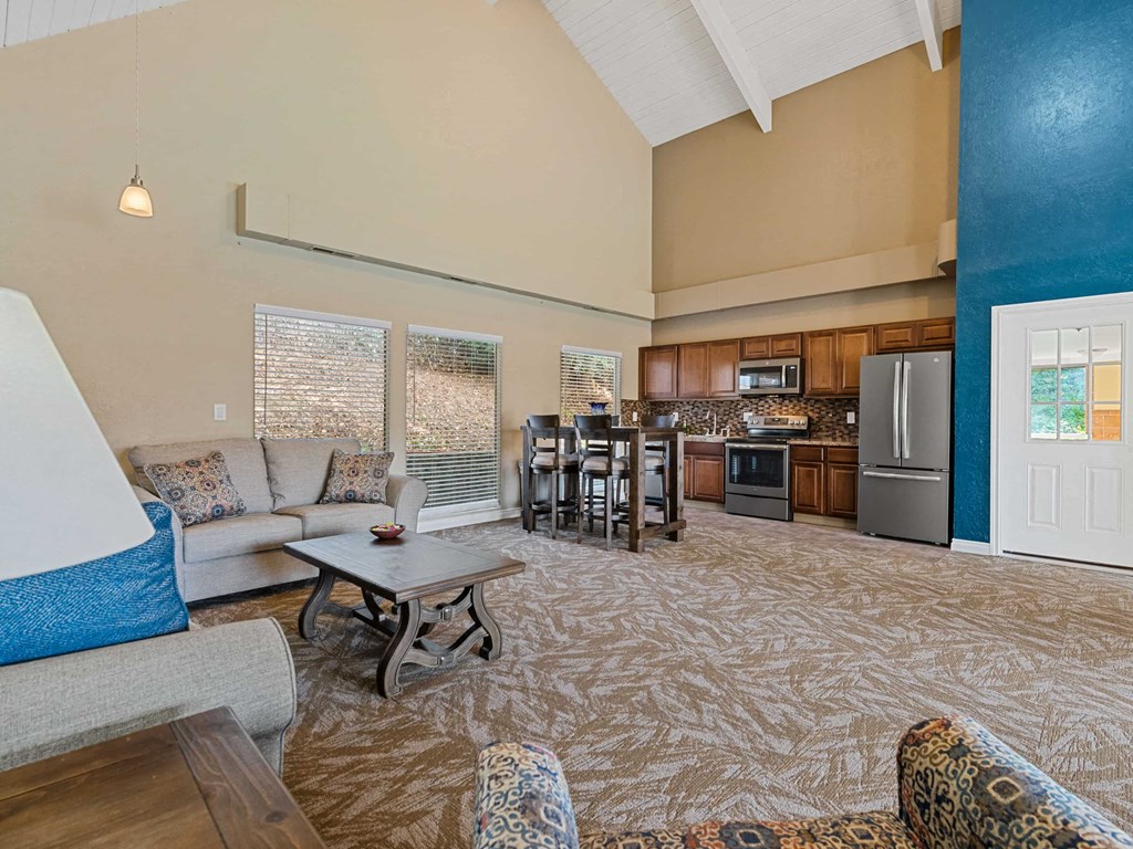 a living room and kitchen with a couch and a table