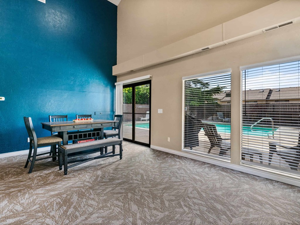 a dining room with a table and chairs next to a pool