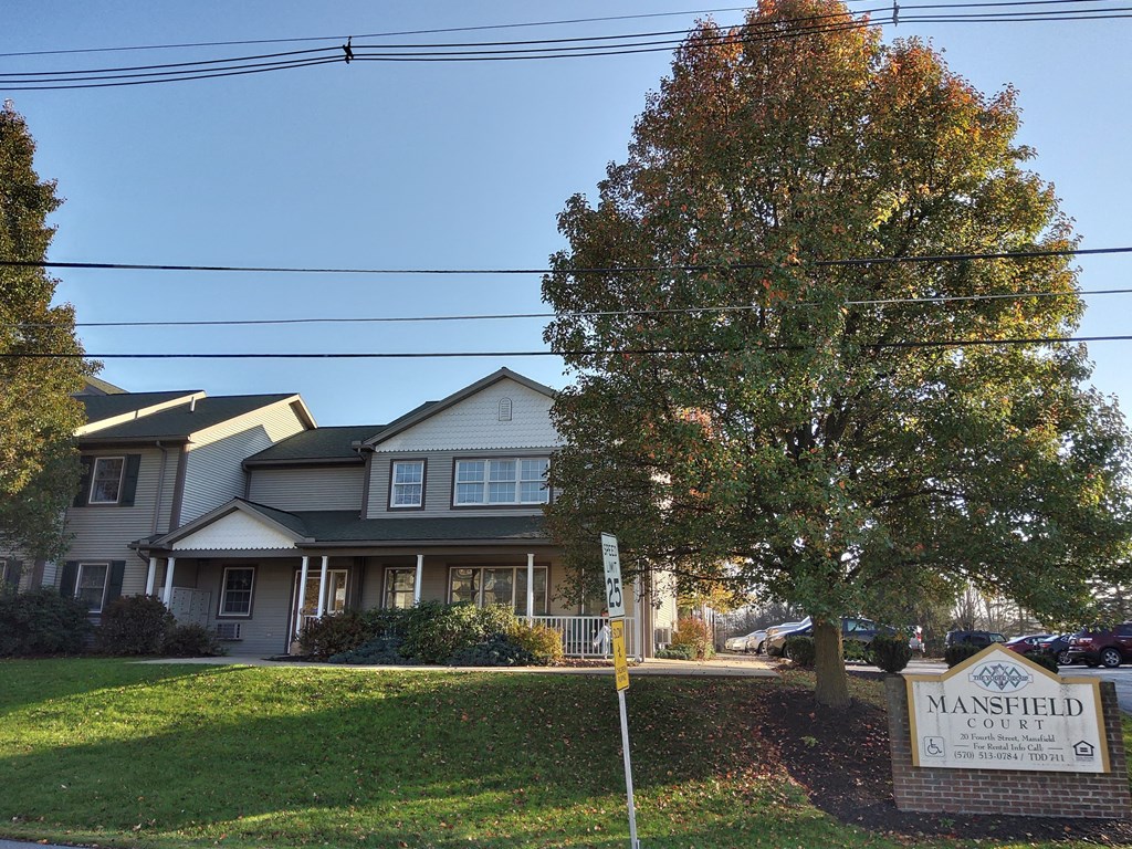 a large house with a sign in front of it