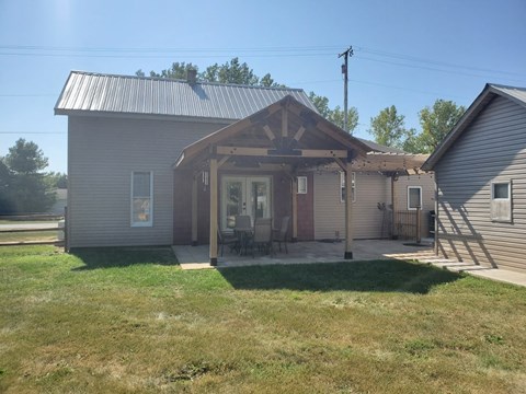 the front porch of a house with a patio and awning