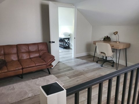 a living room with a couch and a desk