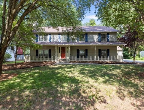 a house with a yard and a red door