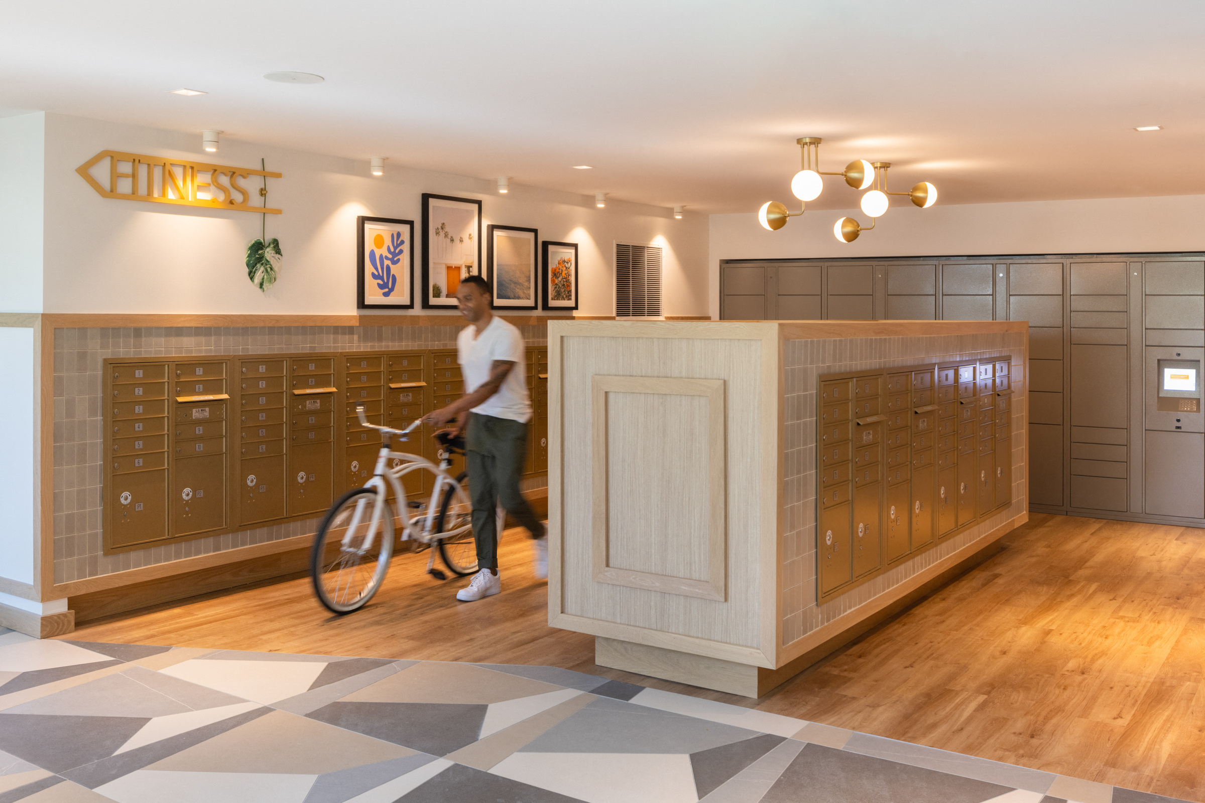 a man holding a bike in a room with a mail room