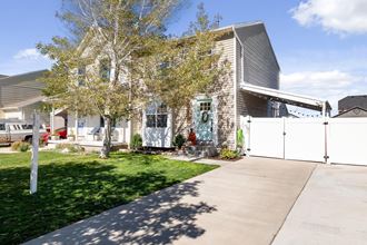 the exterior of a house with a yard and a white fence
