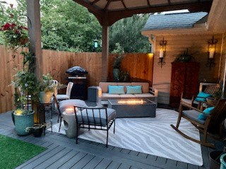 a patio with couches and chairs on a deck