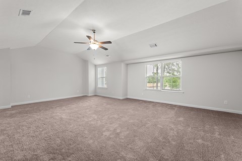 an empty living room with a ceiling fan and a window