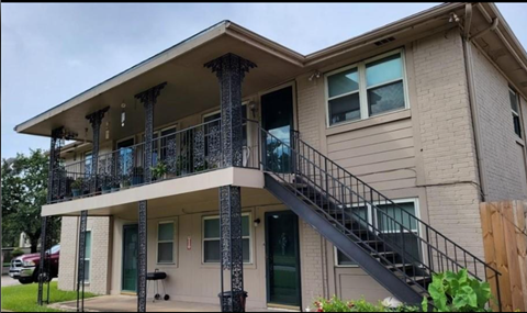 A two-story house with a balcony and staircase.