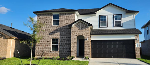 a brick house with a black garage door