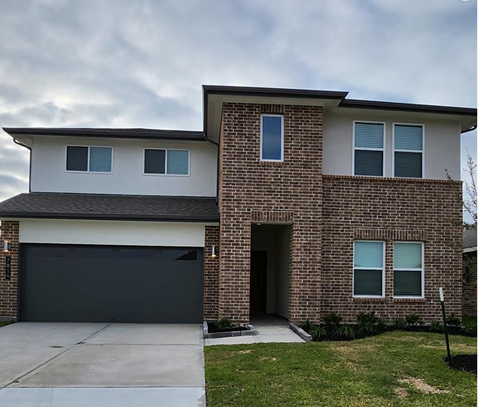 a brick house with a black garage door