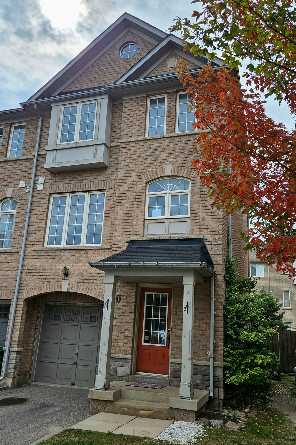 A red door is on the front of a brick building.