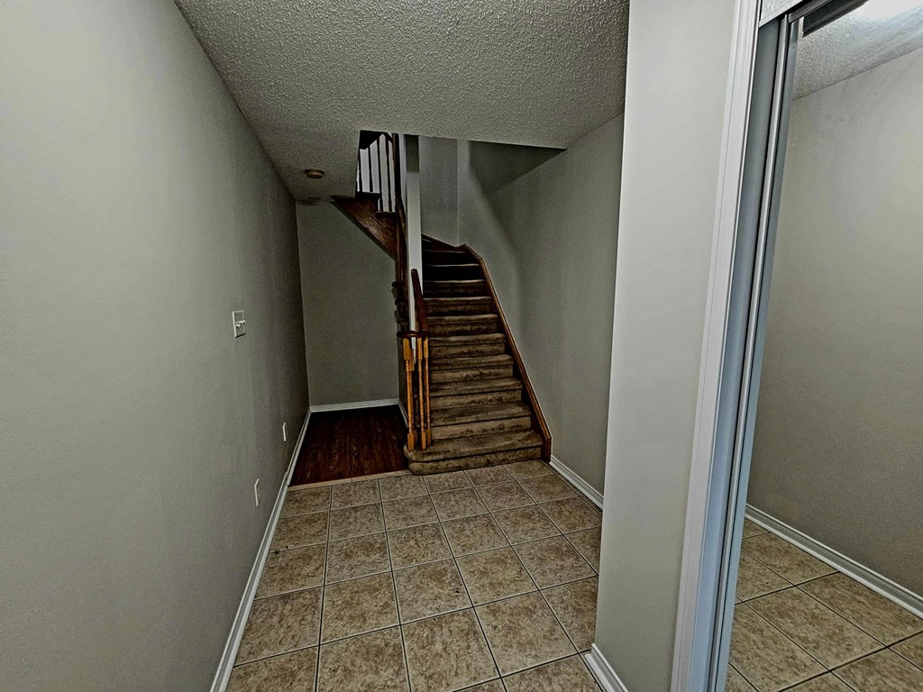 A hallway with a staircase leading to a second floor.