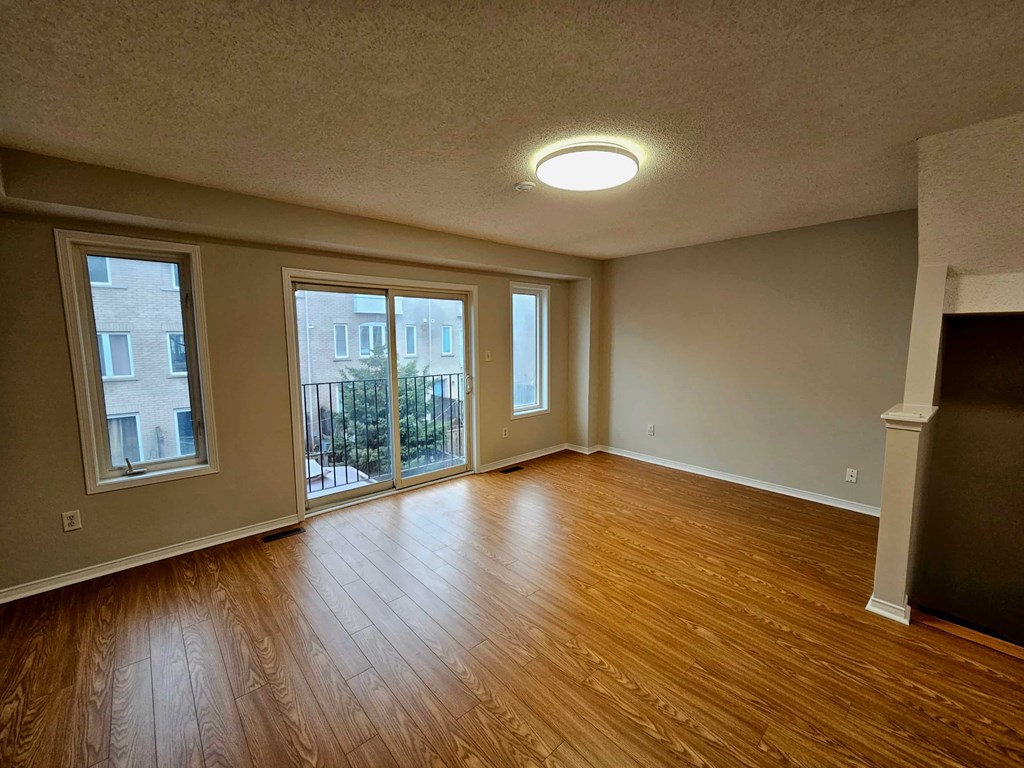 A room with wooden floors and a sliding glass door.