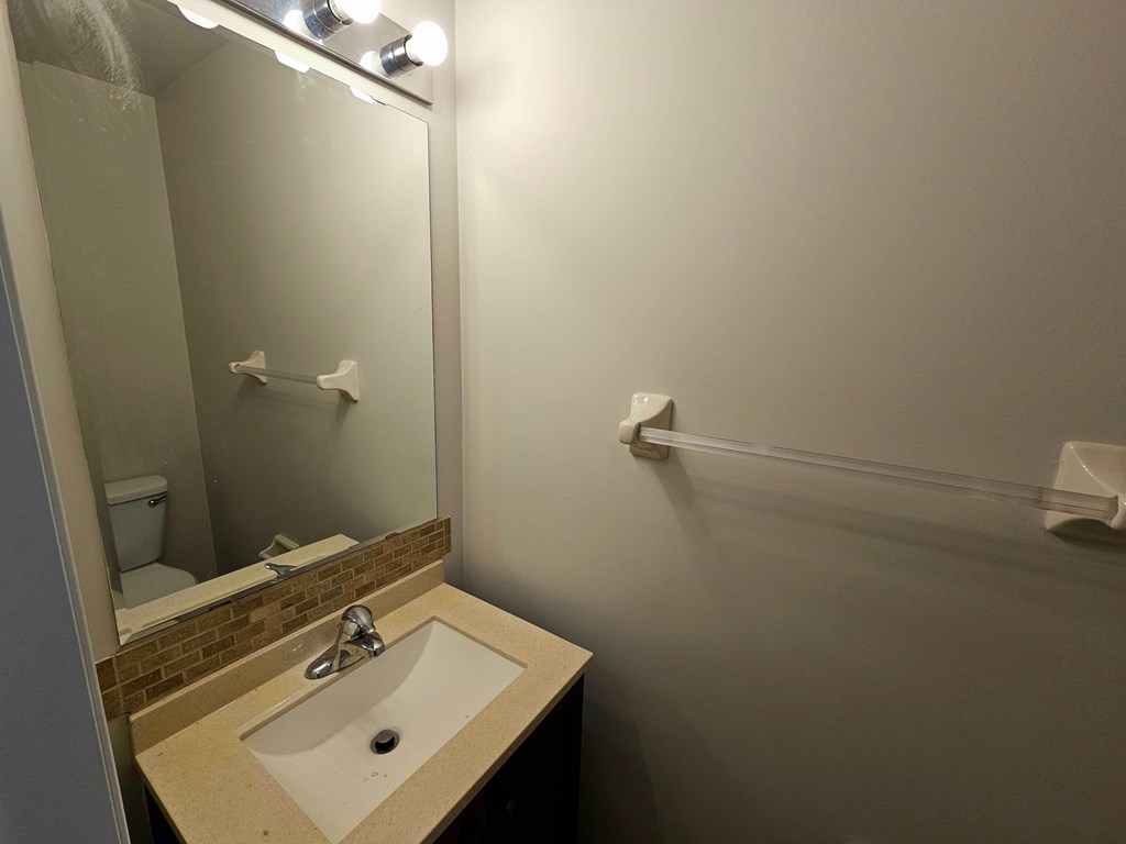 A bathroom with a sink and mirror.